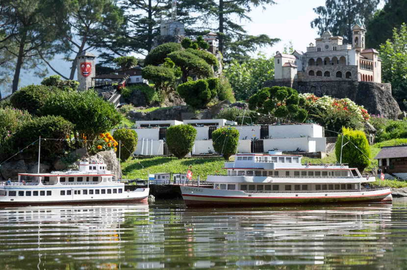 Zoom: Miniaturausgabe von Schweizer Passagierschiffen auf einem modellierten See. Die detailreiche Szenerie verbindet Schifffahrt, Architektur und Gartenlandschaften im Kleinformat.