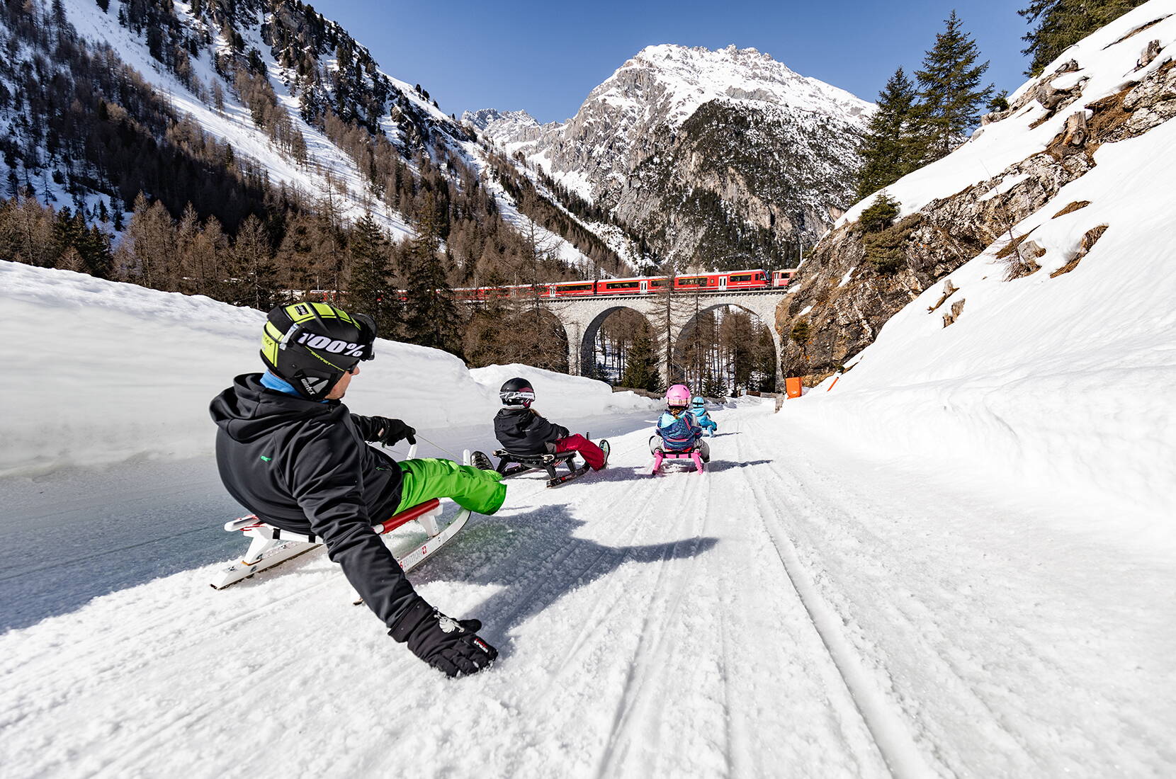 Excursion familiale en luge à Preda-Bergün. Sur la piste de luge unique de Preda-Bergün, tu vivras une expérience de luge unique sur 6 km. Pendant la haute saison, un train de luge part toutes les 30 minutes en direction de Preda, d'où l'on peut descendre tranquillement ou rapidement en luge dans la vallée.