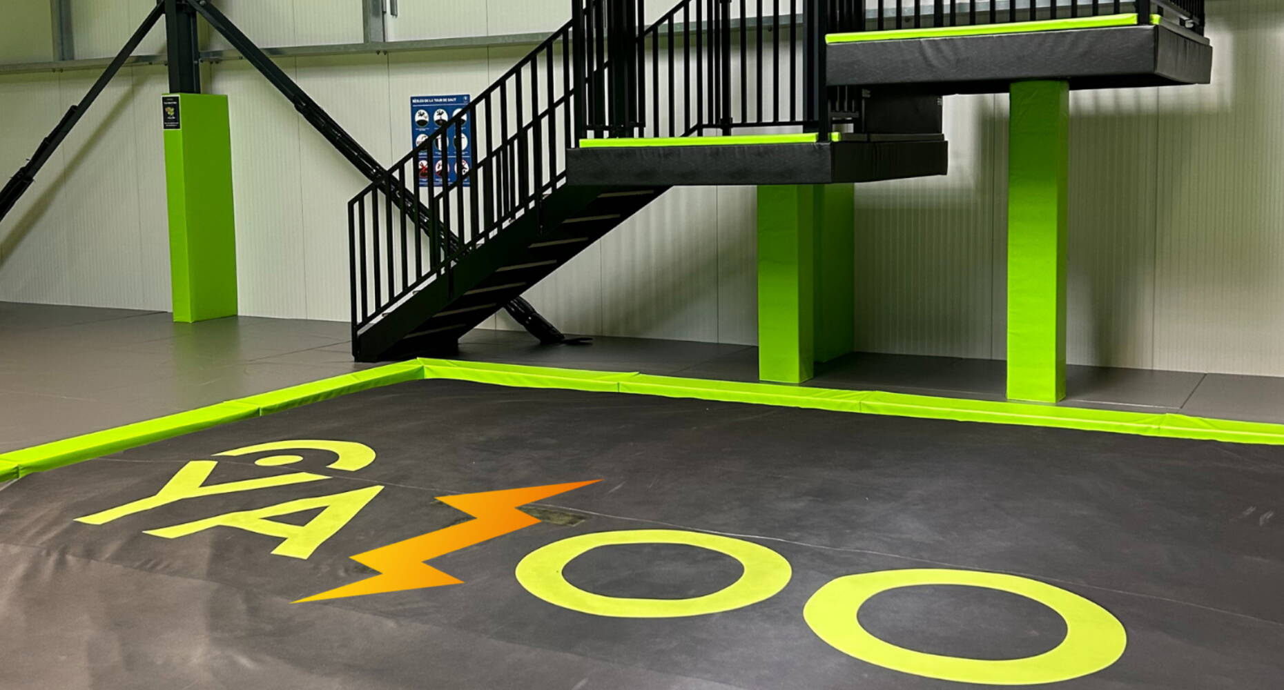 Area di ricezione imbottita con logo Yazoo, progettata per attività di trampolino e salti in tutta sicurezza.