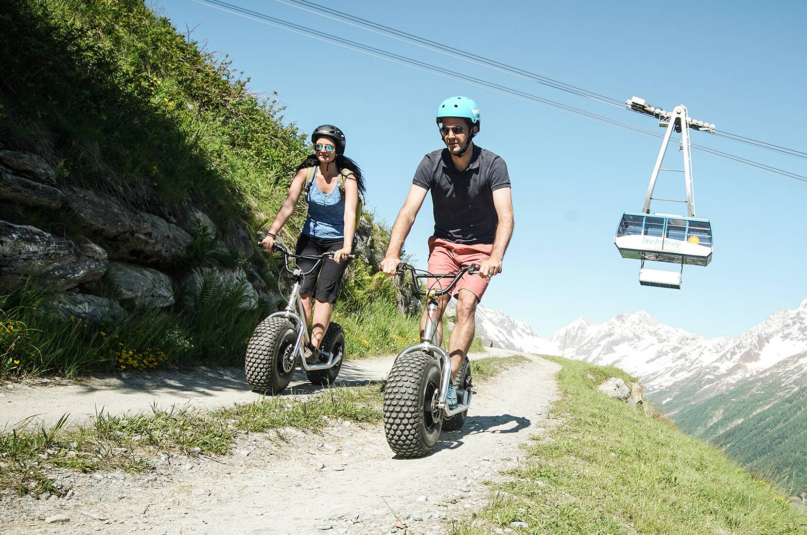 À la station supérieure du téléphérique Wiler-Lauchernalp, tu prends possession de ton trottinette géante et c'est parti! Que ce soit pour couronner ta randonnée ou simplement pour le plaisir, fonce sur la route bien aménagée qui descend vers Wiler.