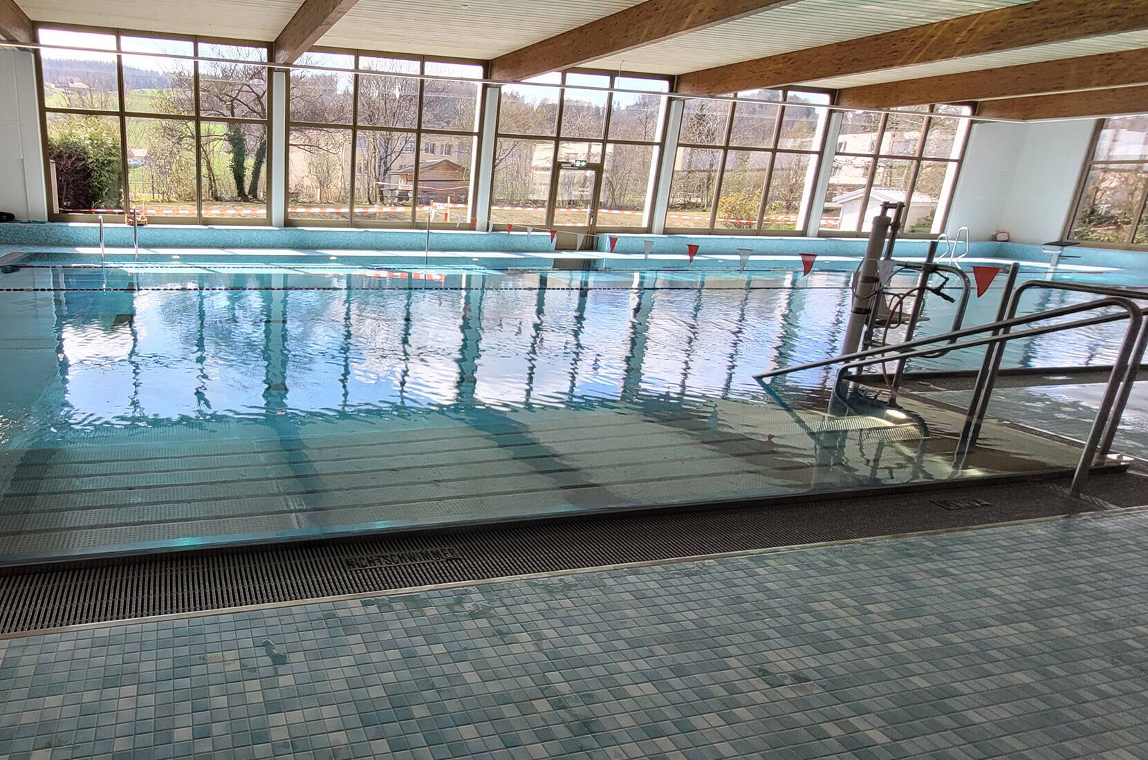 Elle propose un bassin de 25 mètres, une pataugeoire aménagée avec soin, un jacuzzi bouillonnant ainsi qu’une infrastructure moderne accessible aux personnes en situation de handicap – avec un élévateur de piscine et des douches et WC sans barrières.