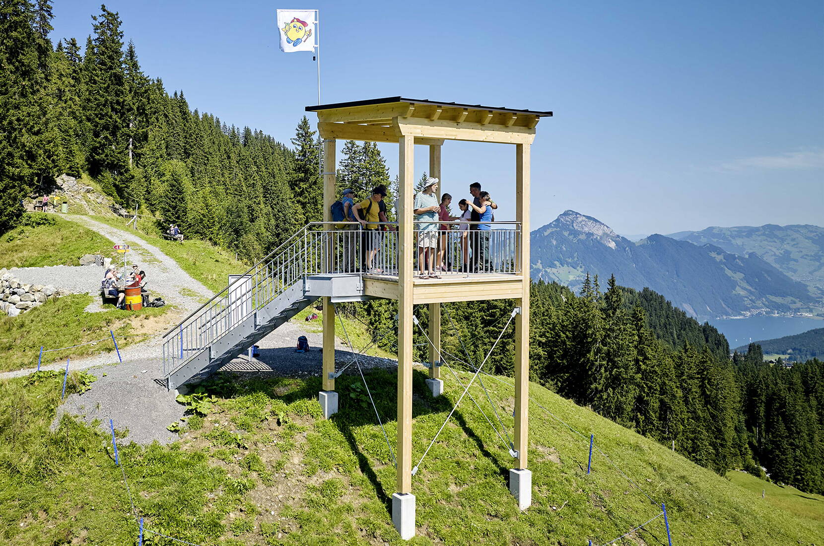 Eine Gruppe Besucher steht auf dem Aussichtsturm des Goldi Gwundernasenwegs.