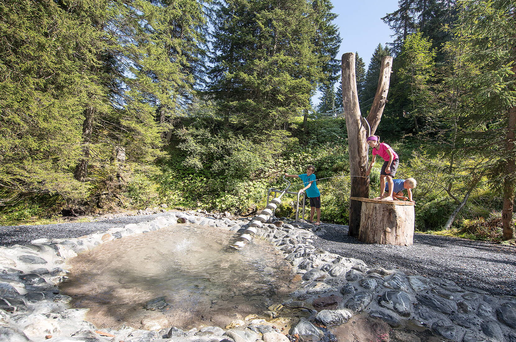 Familienausflug Wasserwald Pizol. Der Wasserspielplatz liegt in einer idyllischen Waldlichtung mit Bach und Wasserfall auf der Furt am Pizol.