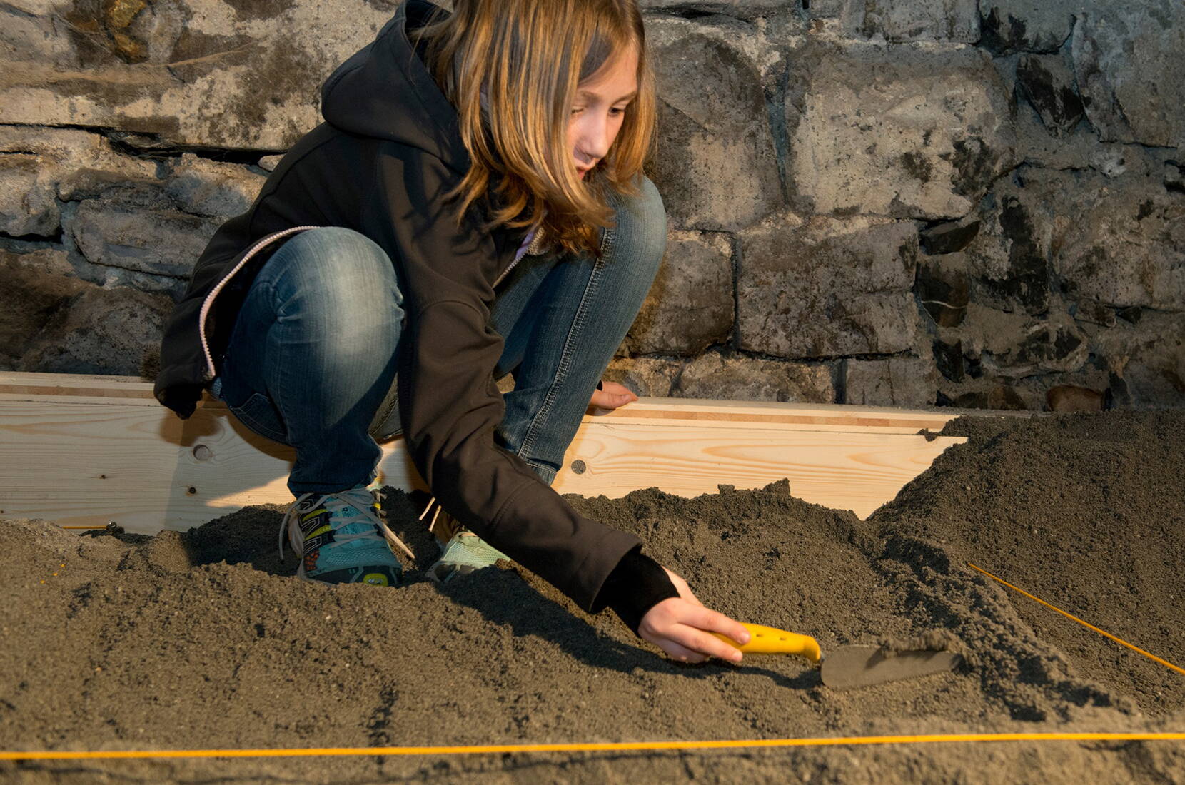 Familienausflug Schloss Werdenberg. Kleine ArchäologInnen heben unter der Leitung einer Fachperson entdeckte Fundstücke korrekt aus der Erde, ordnen sie und besprechen deren Bedeutung.