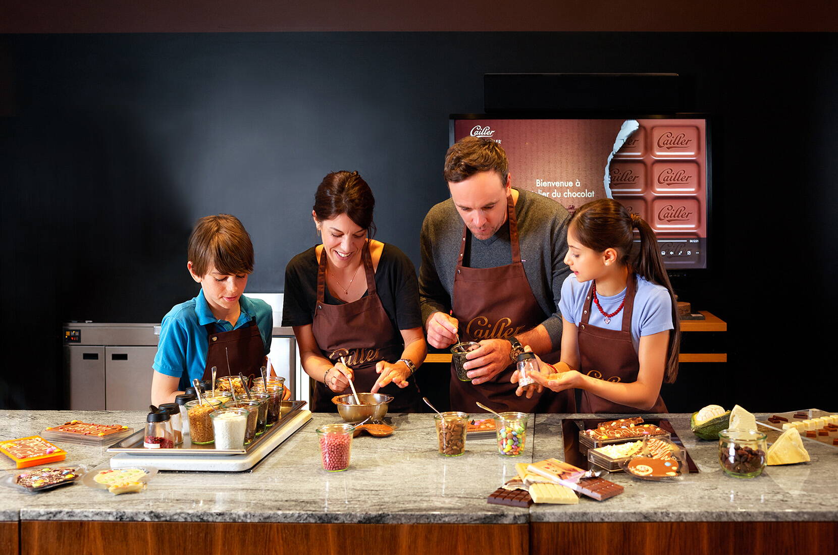 Un gruppo crea e decora il cioccolato durante l’atelier di Maison Cailler.