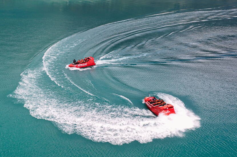 Zoom: Due Jetboat rossi disegnano ampie curve sulla superficie turchese del Lago di Brienz. Le scie bianche formano linee eleganti sull’acqua, mentre i passeggeri vivono un’esperienza veloce nel cuore della natura.