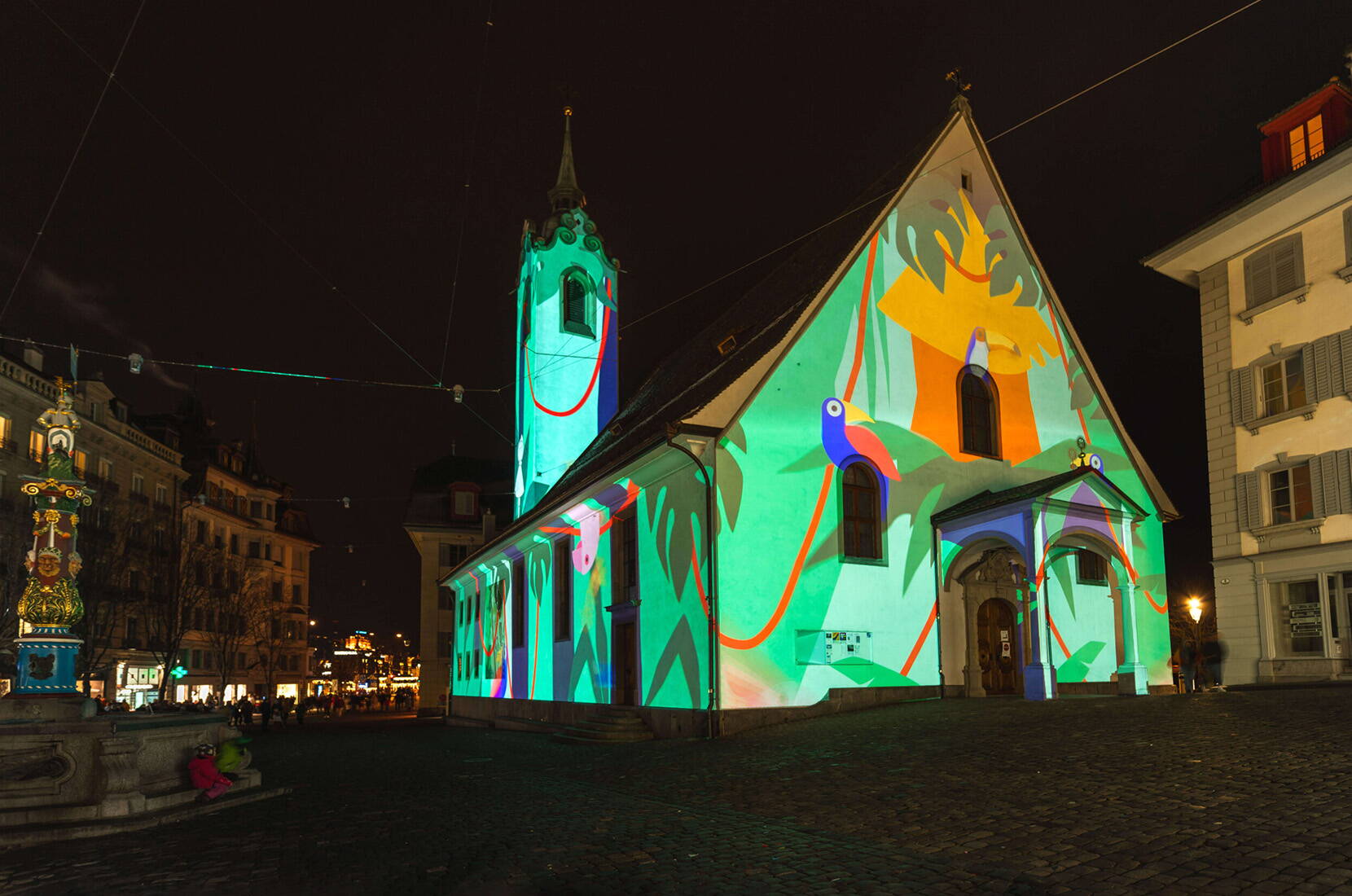 Die Fassade der Kirche wird durch farbenfrohe Projektionen in ein lebendiges Kunstwerk verwandelt. Ein Highlight für Fotografie-Fans.