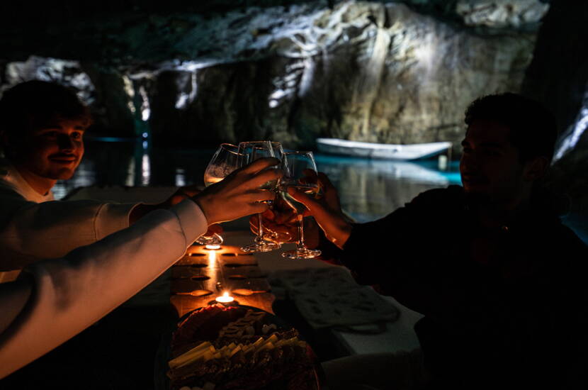Zoom: Une plateforme sur la barque montre une scène chaleureuse dans le Lac Souterrain St‑Léonard, entourée de lumière douce et de parois rocheuses.