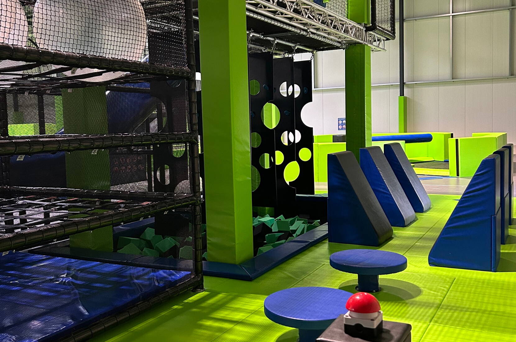 Zona gioco dinamica con strutture da arrampicata, blocchi imbottiti e piattaforme colorate per sfide divertenti e sicure.