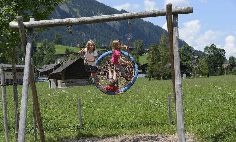 Zoom: Gita in famiglia Parco giochi AlpKultur Lenkerseeli. Con un ponte sospeso di corda, un tavolo d'acqua, scivoli, un percorso sensoriale, un labirinto di siepi, un Mikado per arrampicarsi, un'altalena per sedie a rotelle, una giostrina, un modellino di teleferica, campanelli, tubi per gattonare e altalene, si possono trascorrere diverse ore all'aperto.