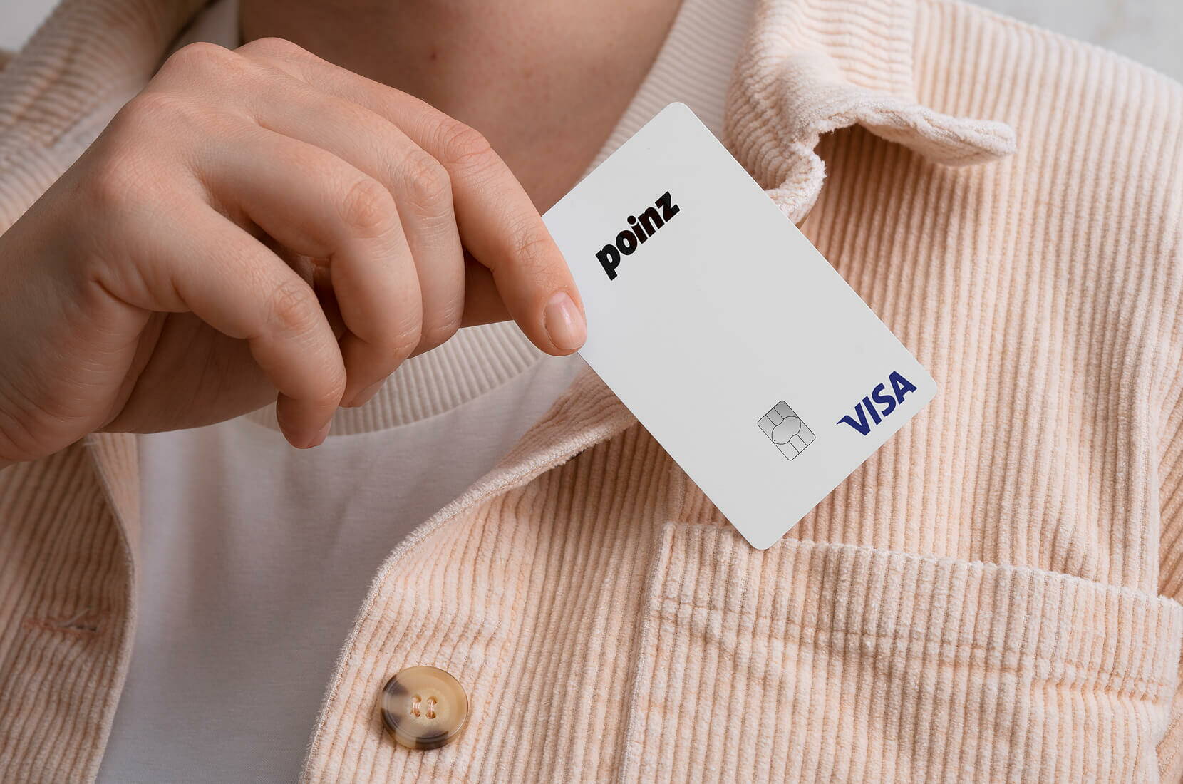 Persona che infila la carta Visa poinz bianca nella tasca della camicia.