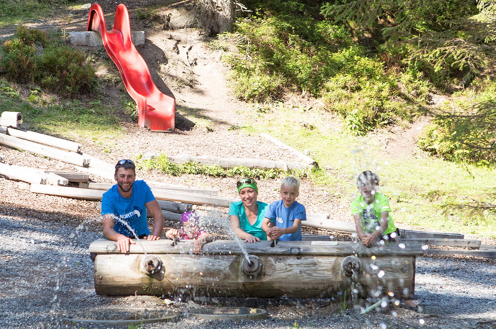 Excursion familiale dans la forêt d'eau. L'aire de jeux aquatiques se trouve dans une clairière idyllique avec un ruisseau et une cascade sur le gué du Pizol.