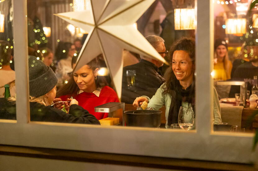 Gastronomie beim Eiszauber Luzern - Wintergenuss für Paare und Familien Gemütliche Gastronomiestände beim Eiszauber Luzern mit lächelnden Gästen, perfekt für warme Getränke nach dem Eislaufen
