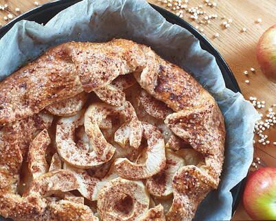 Rezept Apfel-Galette – Aus einem Teig aus Dinkelmehl, Quinoapops, Salz, Zucker, Butter und Wasser fertigst du den Teig. Belegt wird die Galette mit Äpfeln (z.B. Braeburn oder Pink Lady). Den Guss fertigst du aus Zucker, Vanillezucker & etwas Zimt. Den Rand auf der Innenseite mit Apfelmus bestreichen