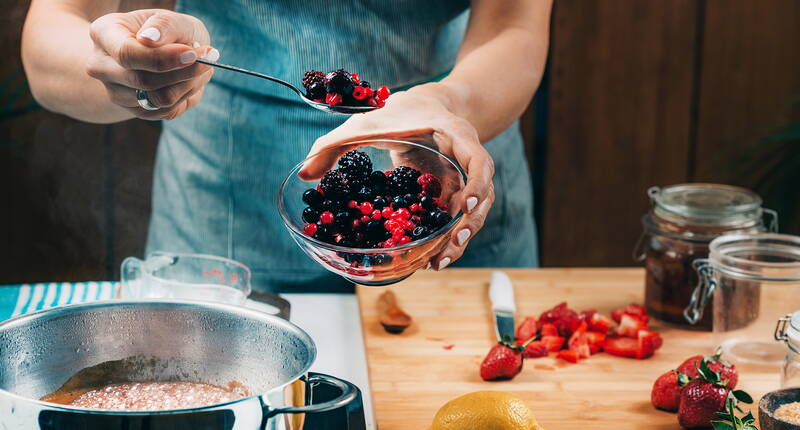 Frische Waldbeeren werden sorgfältig vorbereitet und direkt in den Kochtopf gegeben – der erste Schritt zu einer aromatischen, hausgemachten Konfitüre.