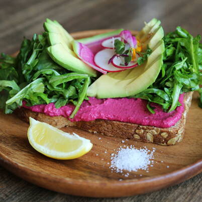 Ein farbenfroher Randenaufstrich auf knusprigem Brot, kombiniert mit Avocado, Rucola und Radieschen, bringt dir frische und gesunde Genussmomente.
