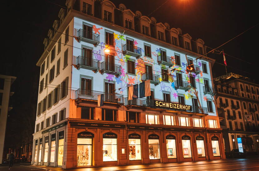 Lichtprojektion am Hotel Schweizerhof Luzern Die historische Fassade des Hotels Schweizerhof wird zur Leinwand für kreative Lichtkunst. Ein farbenfrohes Highlight des Luzerner Lichtfestivals.