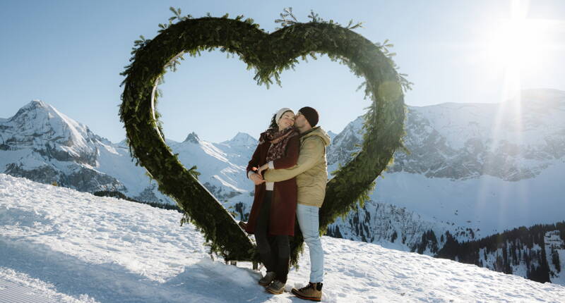 Herzförmiger Fotospot auf dem Winter LoveTrail am VogellisiBerg mit verschneiter Berglandschaft und beeindruckendem Panorama im Berner Oberland.