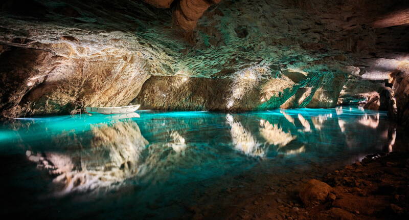Der Lac Souterrain zeigt eindrucksvolle Spiegelungen von Felsformationen im türkisblauen Wasser tief unter dem Wallis.