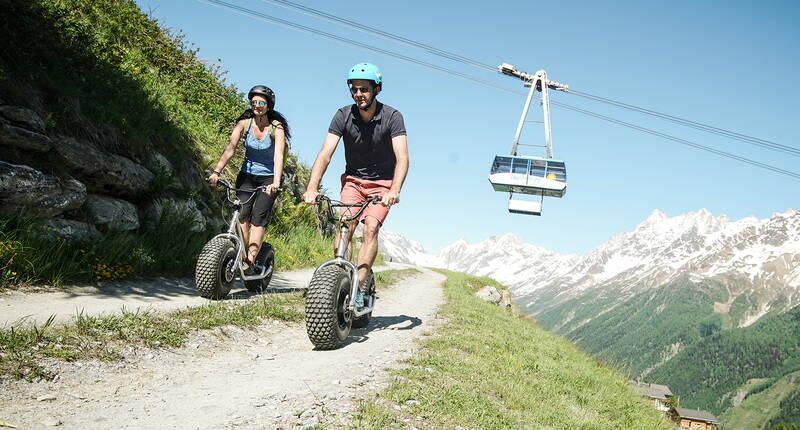 Direkt bei der Bergstation der Luftseilbahn Wiler-Lauchernalp kannst du die Monster-Trottinetts in Empfang und die gut ausgebaute Strasse nach Wiler in Angriff nehmen. Ob als Abschluss einer Wanderung oder einfach als Action-Ausflug – diese Abfahrt hat es in sich.