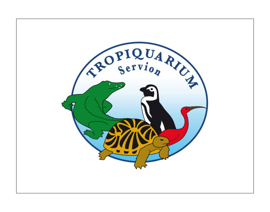 Rundes Logo mit blauem Hintergrund und vier Tieren: grünes Krokodil, schwarz-weisser Pinguin, rote Ibis und gelb-schwarze Schildkröte. Schriftzug „Tropiquarium Servion“.