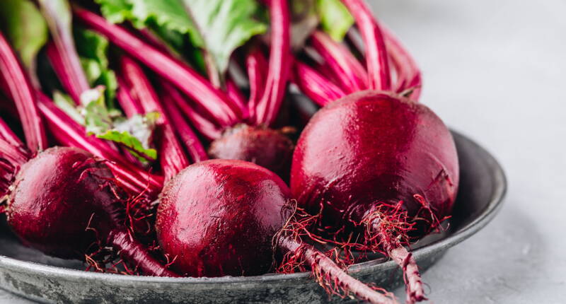Barbabietole appena raccolte con le foglie ti mostrano il loro colore intenso e la loro freschezza naturale – perfette per una cucina sana.
