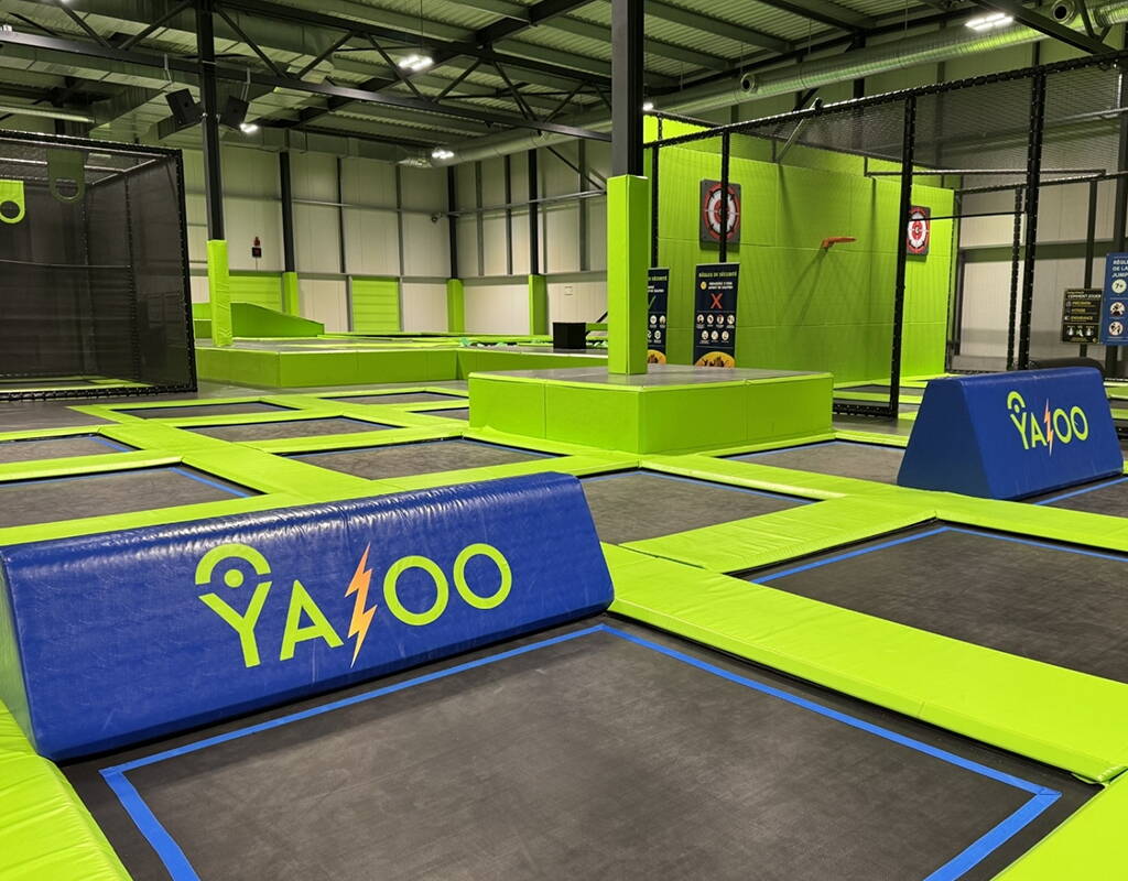 Grosse Trampolin-Zone mit farbigen Schutzvorrichtungen und Spielelementen für Sprünge in völliger Sicherheit.