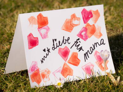 Handgemachte Muttertagskarte mit gestempelten Herzmotiven als einfache DIY‑Bastelidee für Kinder.
