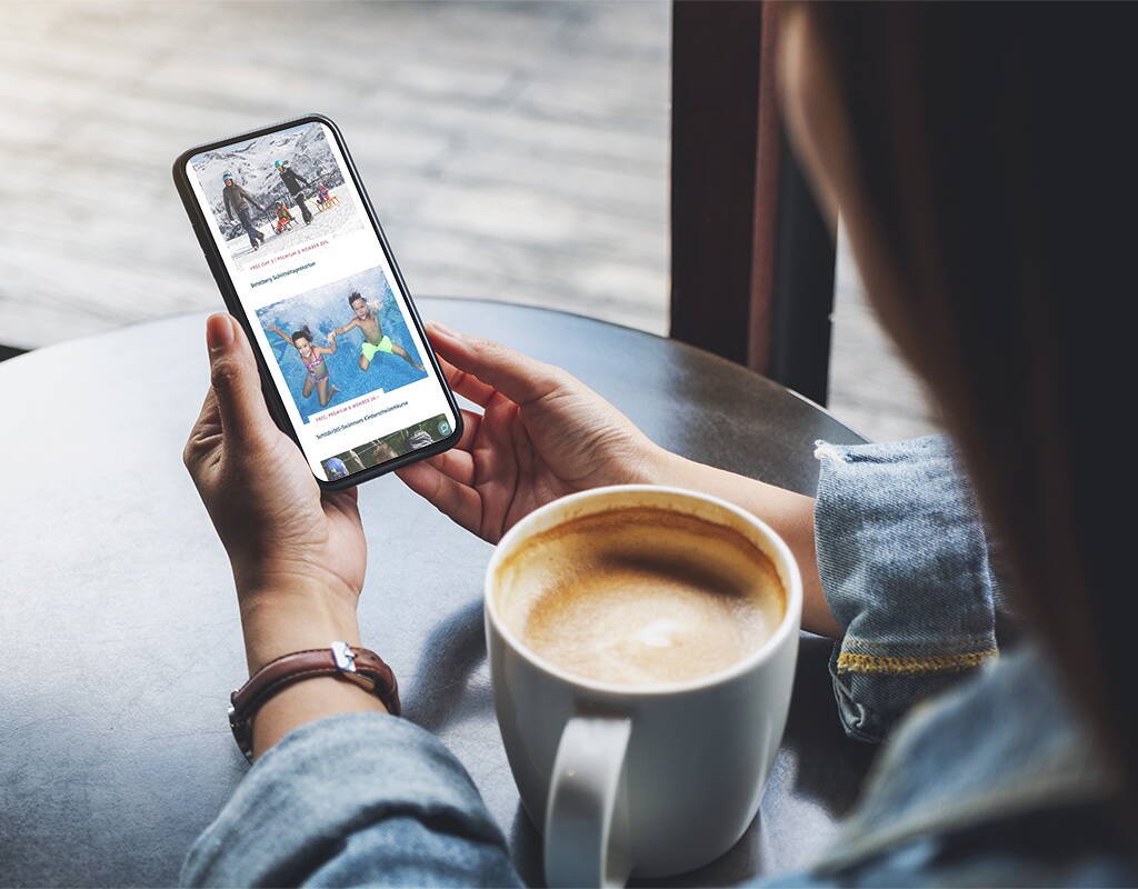 Eine Person geniesst einen Kaffee und stöbert auf dem Smartphone durch inspirierende Freizeitangebote – ideal, um den nächsten Ausflug oder eine Aktivität spontan zu planen.