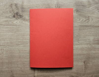 DIY Papierportemonnaie – Ausgangsmaterial rotes Papier Ein halbiertes rotes A4‑Papier liegt flach auf dem Tisch und bildet die Ausgangsbasis für das DIY Papierportemonnaie. Dieses rechteckige Papierstück ist der erste Schritt im Faltprozess und sorgt für eine saubere Grundlage für das spätere Origami‑Portemonnaie.