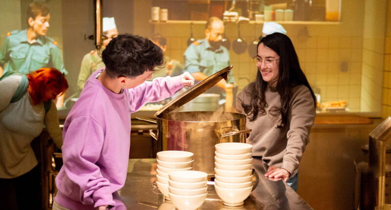 Allestimento impressionante della cucina del forte, con un grande paiolo e attrezzatura militare d’epoca.