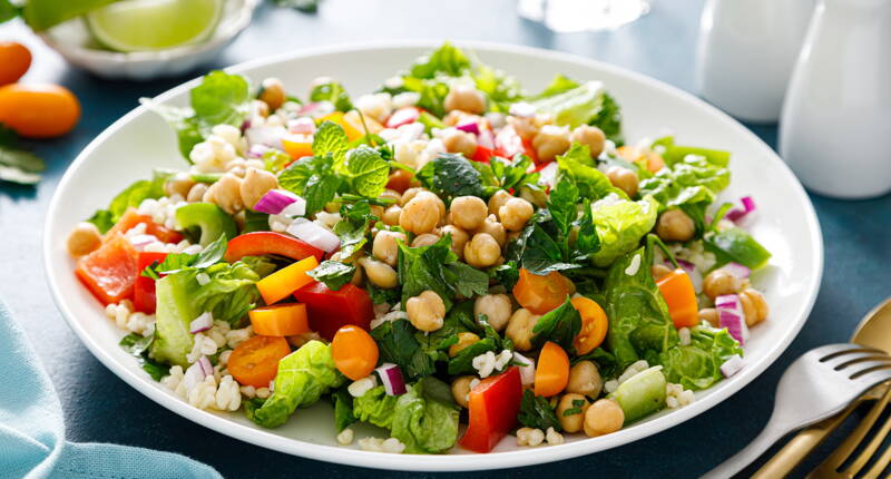 Salade colorée avec pois chiches, riz, poivrons et herbes fraîches comme source de protéines végétales