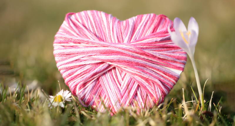 Herzförmiges Bastelmotiv aus rosa Garn als symbolische Muttertags‑Bastelidee für ein persönliches Geschenk.
