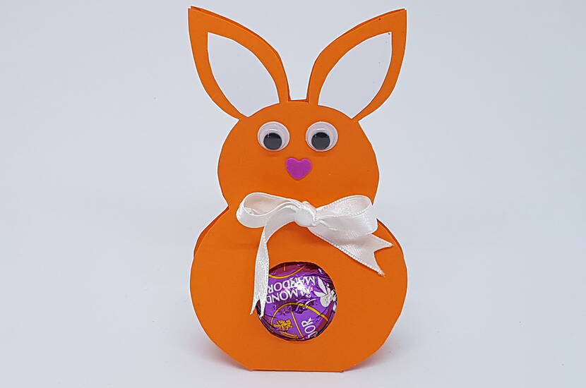 Osterhasenverpackung für Schokoladenkugeln Die perfekte Osterverpackung für leckere Schokoladenkugeln. Lade dir unsere Bastelvorlage herunter und bastele dir Verpackung in Form eines Osterhasen nach.