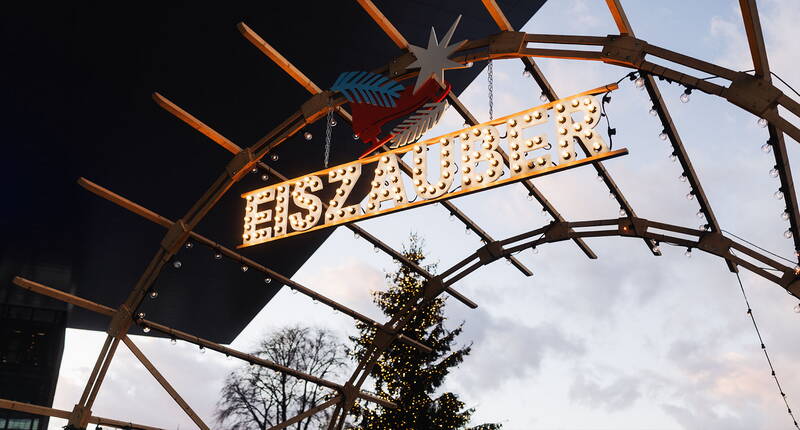 L'ingresso illuminato della Magia del ghiaccio Lucerna con caratteristico arco in legno e atmosfera da mercatino invernale al tramonto