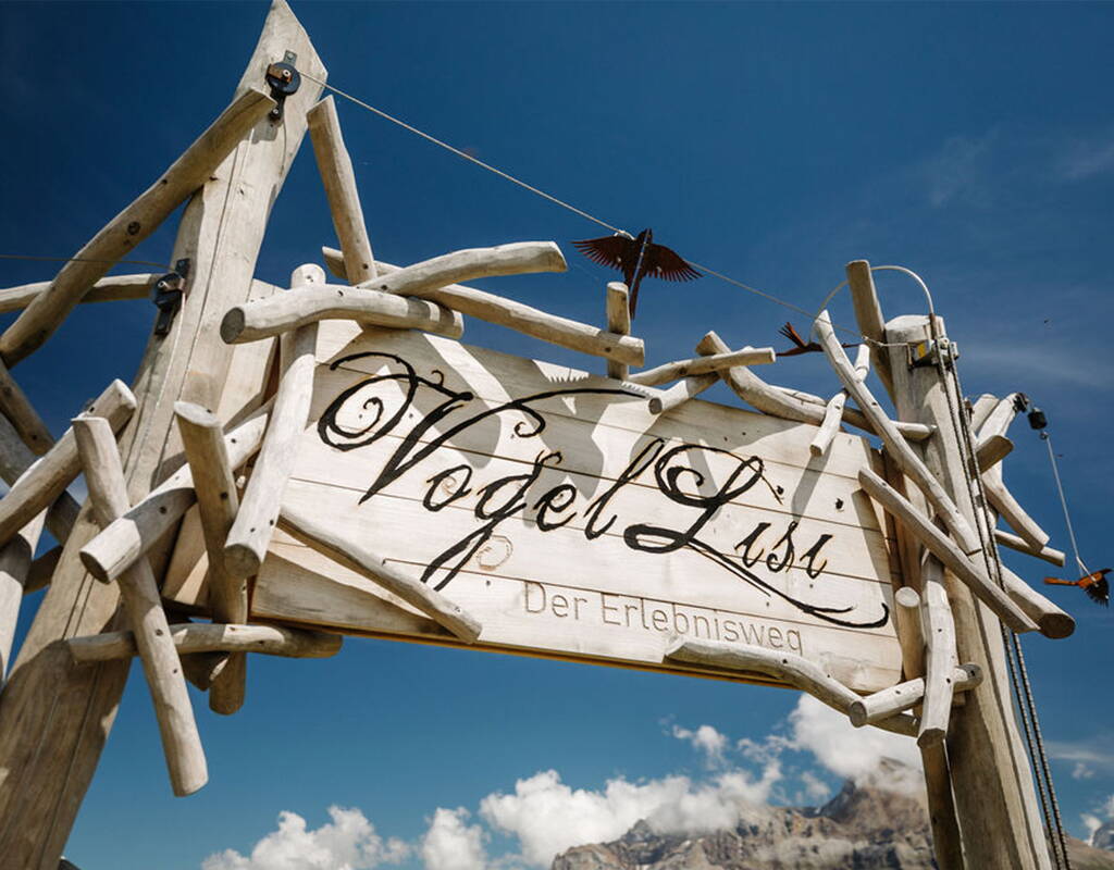 Vogellisi-Erlebnisweg am VogellisiBerg in Adelboden Das Eingangstor zum Vogellisi-Erlebnisweg am VogellisiBerg in Adelboden. Der familienfreundliche Themenweg im Berner Oberland verbindet Natur, Bewegung und die beliebte Vogellisi-Geschichte zu einem abwechslungsreichen Ausflugserlebnis.
