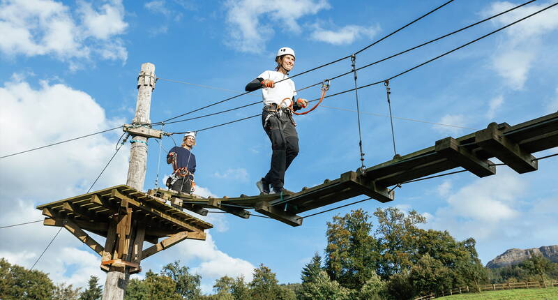 Una persona attraversa un ponte sospeso in totale sicurezza – un’avventura panoramica nella Svizzera centrale.