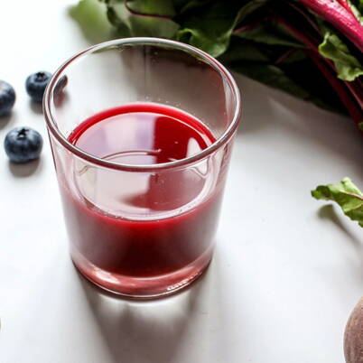 Ein leuchtend roter Randensmoothie im Glas, ergänzt mit frischen Beeren und Randenblättern, liefert dir eine natürliche Portion Energie und wertvolle Vitamine.