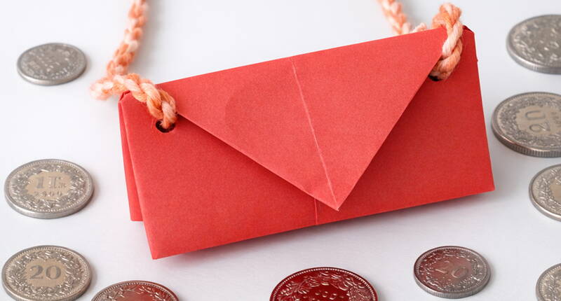 Das vollständig gefaltete Papierportemonnaie zeigt eine saubere, dreieckige Verschlussklappe, die das Innere sicher schützt. Die kompakte Origami‑Form eignet sich perfekt als kleines DIY‑Portemonnaie für Gutscheine, Geldscheine oder Nachrichten. Dieser letzte Schritt vollendet das einfache, aber stilvolle Papierprojekt.