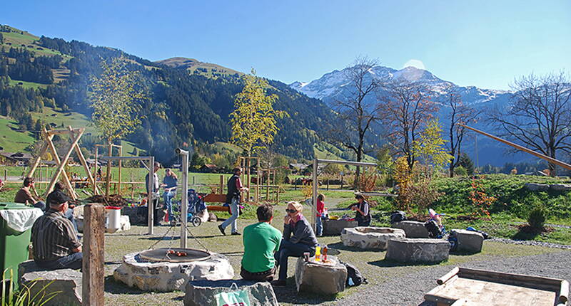 Excursion familiale aire de jeux AlpKultur Lenkerseeli. Pont suspendu, table d'eau, toboggans, sentier sensoriel, labyrinthe de haies, mikado d'escalade, bascule pour fauteuil roulant, mobile de jeu, maquette de tyrolienne, carillon, tubes rampants et balançoires permettent de passer des heures variées en plein air.