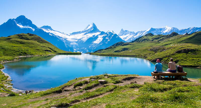 Famiglia in escursione nelle Alpi svizzere con vista su un lago di montagna - attività ricreative economiche con MiBon