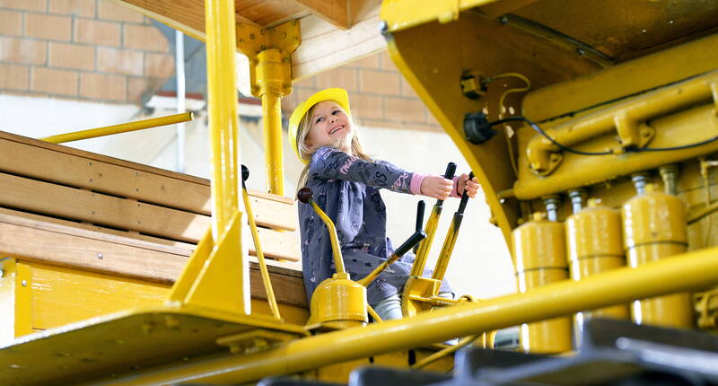 Ausflugsziele Mittelland - Familienausflug ins EBIANUM Baggermuseum. Die kleinen Besucher im Sandkasten verweilen, mit Baumaschinen im Mini-Format Baustelle spielen, verschiedene Trettraktoren, Stapler und Bobby Cars ausprobieren und in einem echten Bagger, Lastwagen, Dozer, Traktor & Trax zu sitzen