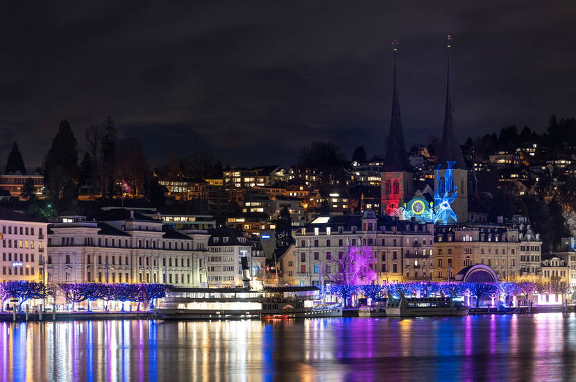 Luzern im Lichterglanz am Seeufer Die Stadt Luzern erstrahlt in bunten Farben. Kirchen, Häuser und Uferpromenade sind kunstvoll illuminiert und spiegeln sich im Wasser des Vierwaldstättersees.