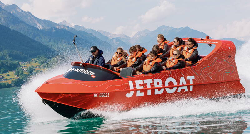 Un Jetboat rosso sfreccia ad alta velocità sul Lago di Brienz e mostra la combinazione perfetta tra azione sull’acqua e paesaggio alpino nell’Oberland bernese.