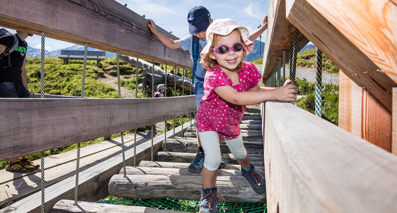 Le long du chemin, il y a des stations de jeu passionnantes et amusantes, équipées de panneaux d'information, qui aident à mieux connaître la marmotte et son habitat. Les enfants apprécient particulièrement la construction de la marmotte sur laquelle on peut marcher, la passerelle branlante, la tyrolienne et le labyrinthe.