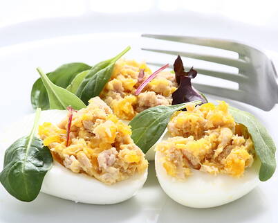 Œufs garnis d’une farce au thon relevée et de jeunes pousses fraîches.